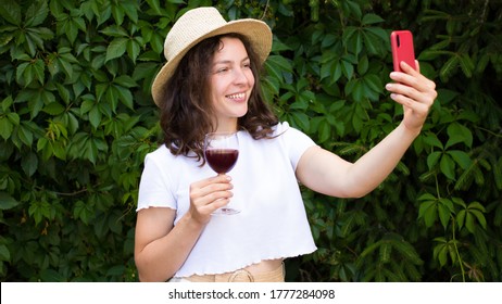 Happy young smiling caucasian woman making video call with smartphone in green park outdoor.Best friends drinking red wine and toasting.Video conference party online meeting with family,Branch,picnic - Powered by Shutterstock