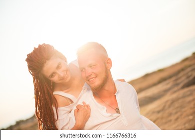 happy young smiling loving nordic man and arabic woman with dreadlocks on summer sunset