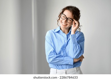 Happy young smiling professional business woman, happy pretty lady manager leader executive wearing glasses looking away, laughing, standing indoors in office space, authentic candid shot. - Powered by Shutterstock