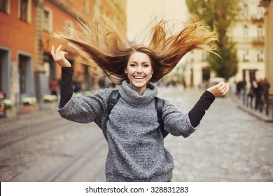 Happy Young Smiling Woman Playing With Her Long Beautiful Hair. Emotional Portrait