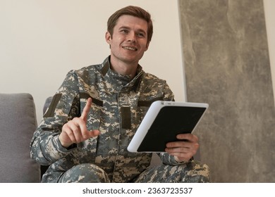 Happy young soldier holding a computer tablet - Shutterstock ID 2363723537
