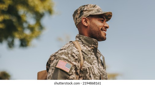 Happy young soldier smiling cheerfully while standing outside his home. Patriotic American serviceman coming back home after serving his country in the military. - Shutterstock ID 2194868161