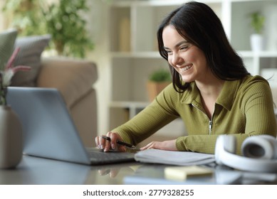 Happy young student elearning using laptop at home