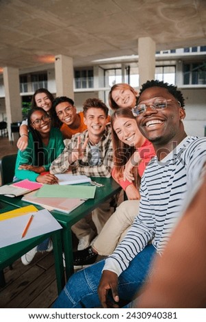 Happy young students taking a vertical selfie portrait together at university library. African american guy shooting a photo with his smiley classmates on a high school meeting. Friends at academy