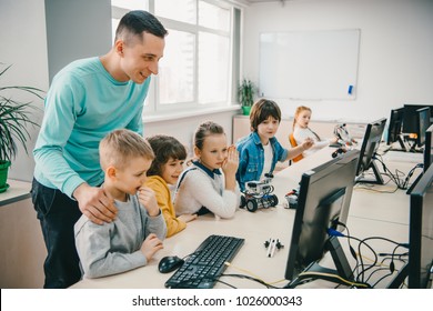 Happy Young Teacher Helping His Teen Students With Diy Robot On Stem Education Class