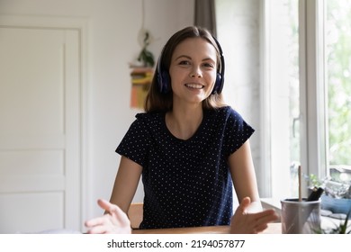 Happy Young Teacher Woman In Wireless Headphones Giving Online Lesson, Class, Workshop, Training Course, Looking, Speaking, Smiling At Camera, Explaining Webinar To Audience. Head Shot Portrait