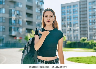 Happy young teenage female with red hair backpack making air kiss gesture - Powered by Shutterstock