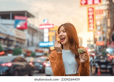 Happy young tourist Asian woman enjoy and fun traditional asian street food at Bangkok Chinatown, Female shopping and eating street food on summer holiday vacation. - Powered by Shutterstock