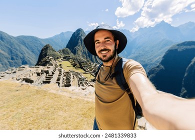 Happy young traveler man taking selfie portrait while enjoying vacation in Peru. Joyful tourist visiting Machu Picchu. Travel and holiday lifestyle concept. - Powered by Shutterstock