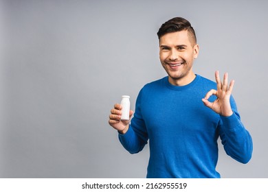 Happy Young Ukrainian Handsome Man Drinking Probiotic Yogurt Isolated Over Grey White Background. Healthy Lifestyle Concept.