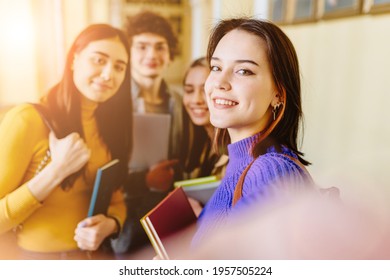 Happy Young University Students Making Selfie Photo Together While Studying In High School. Group Of People Friends In College Standing Together Hugging And Smiling. Sun Glare Effect.