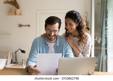 Happy young wife embrace shoulders of beloved husband reading official paper letter of getting job promotion loan mortgage approval. Glad married couple impressed with perfect news received by mail - Shutterstock ID 1910862748