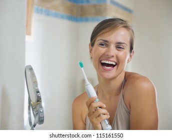 Happy Young Woman After Brushing Teeth With Electric Toothbrush