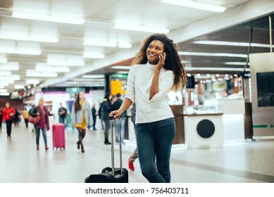 Happy Young Woman At Airport Talking On Phone.