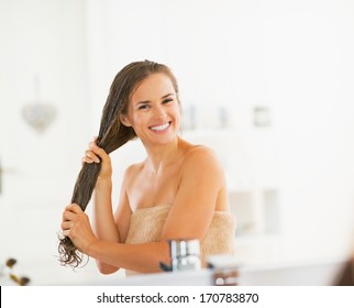 Happy Young Woman Applying Hair Mask In Bathroom