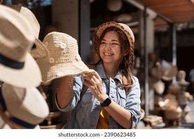 Happy young woman asian is visit local market during her trip and purchase straw hat handmade. Tourist women travel in Chiang mai enjoy shopping market during holidays, backpacker traveller - Powered by Shutterstock