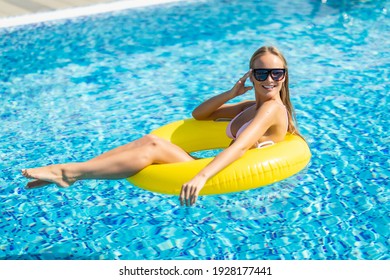 Happy Young Woman In Bikini With Rubber Inflatable Float, Playing And Having A Good Time At Water Fun Park Pool, On A Summer Hot Day