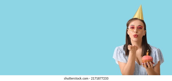 Happy Young Woman With Birthday Cake Blowing Kiss On Light Blue Background With Space For Text