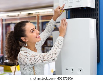 Happy Young Woman Buying New Heating Water Boiler In Supermarket
