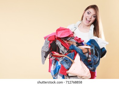 Happy Young Woman Carrying Stack Pile Of Dirty Laundry Clothes. Girl Cleaning Tidying In Studio.