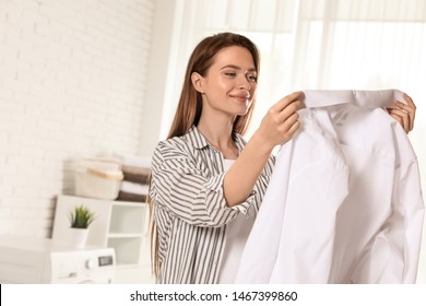 Happy Young Woman With Clean Shirt Indoors. Laundry Day