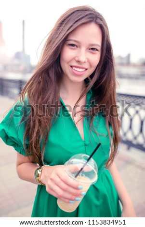 Happy young woman with coffee to go in european city