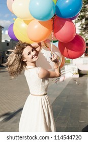 Happy Young Woman With Colorful Latex Balloons Keeping Her Dress, Urban Scene, Outdoors