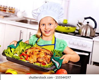 Happy Young Woman Cooking Chicken At Kitchen.