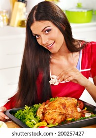 Happy Young Woman Cooking Chicken At Kitchen.