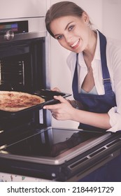 Happy Young Woman Cooking Pizza At Home