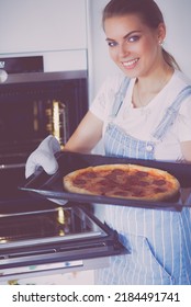 Happy Young Woman Cooking Pizza At Home