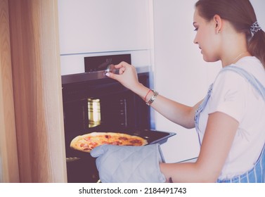 Happy Young Woman Cooking Pizza At Home