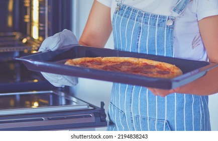 Happy Young Woman Cooking Pizza At Home