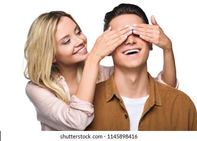 happy young woman covering her boyfriends eyes from behind isolated on white