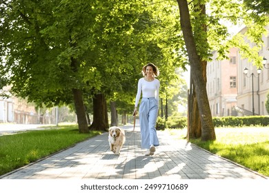 Happy young woman with cute Australian Shepherd dog walking in park - Powered by Shutterstock