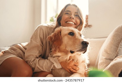 Happy young woman with dog on sofa in cozy living room at home relaxing and unwinding on weekend, hugging and playing with her pet. - Powered by Shutterstock