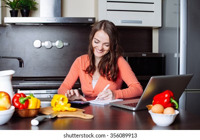 Happy young woman is doing banking and administrative work holding bills at home - Shutterstock ID 356089913