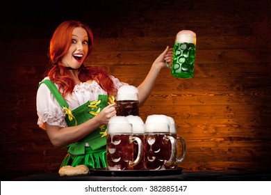 Happy Young Woman  Dressed a Traditional St. Patrick's Day with Six Glasses of Beer on the Wooden Background