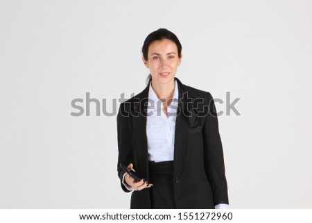  Happy young woman drinking hot beverage at office. Charming blonde female holding a coffee cup and cellphone