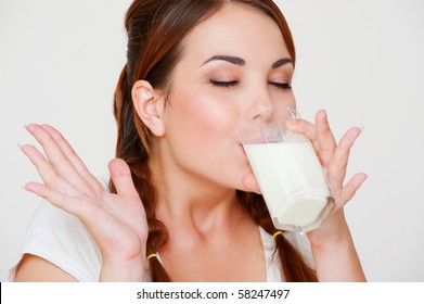 Happy Young Woman Drinking Milk Over Grey Background