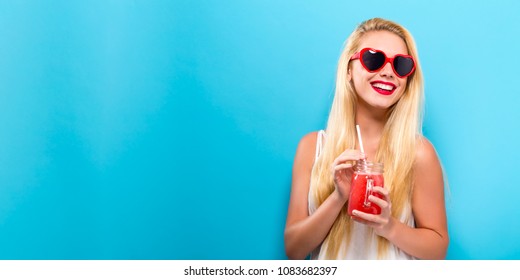 Happy Young Woman Drinking Smoothie On A Solid Background