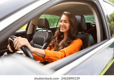 Happy young woman driving car and smiling, enjoying automobile travel, sharing car. Test drive of new vehicle - Powered by Shutterstock