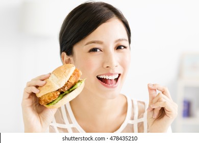 Happy Young  Woman Eating  Big Hamburger