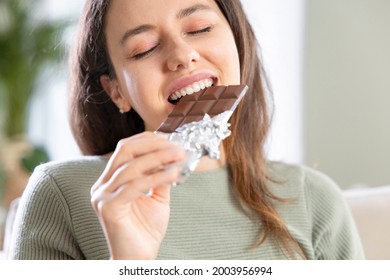 Happy Young Woman Eating Chocolate At Home