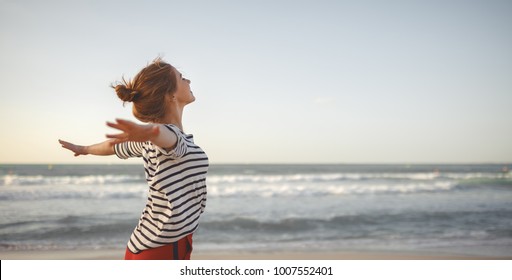 Happy Young Woman Enjoying Freedom With Open Hands On Sea
