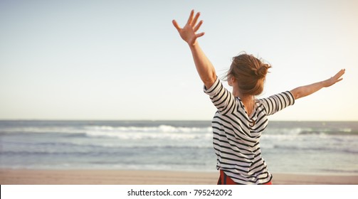 happy young woman enjoying freedom with open hands on sea - Shutterstock ID 795242092