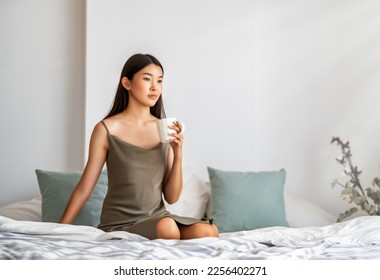 Happy young woman enjoying sunny morning on the bed.