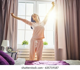 Happy Young Woman Enjoying Sunny Morning On The Bed.