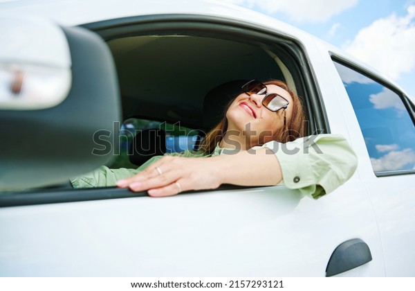 Happy\
young woman enjoys buying a new car or a rental car. The concept of\
buying a new car, renting and freedom of\
movement