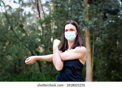 Happy Young Woman Exercising Outdoors With Mask On During COVID-19 Pandemic